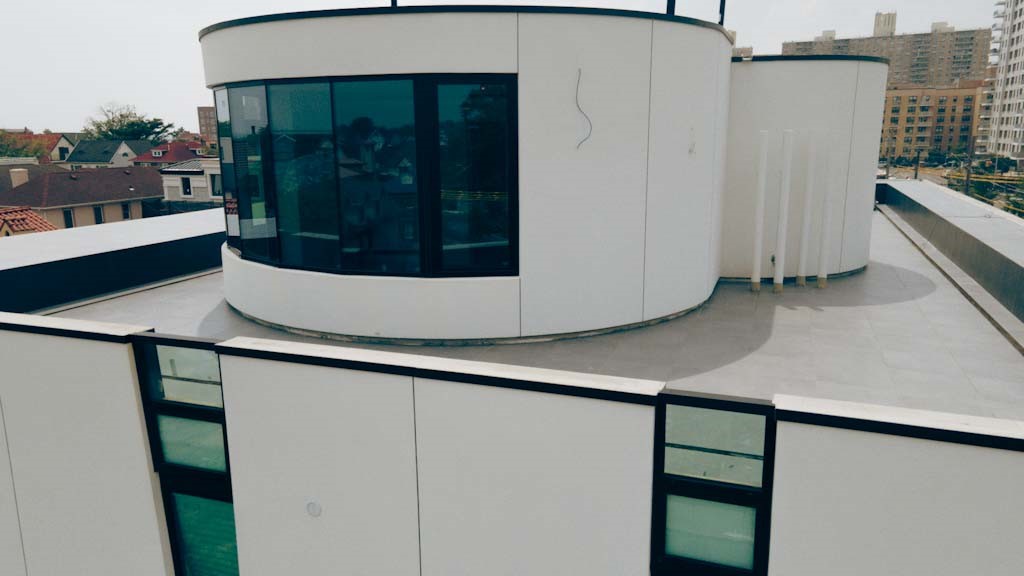 Avrams modern windows and doors on a Manhattan Beach Brooklyn coastal home with curved glass and aluminum frames